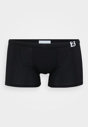 Schwarze Boxershorts aus dehnbarem Material, mit enger Passform, nahtlosem Design und einem kleinen weißen Markenetikett am Bund.