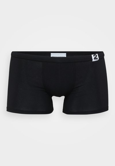 Schwarze Boxershorts aus dehnbarem Material, mit enger Passform, nahtlosem Design und einem kleinen weißen Markenetikett am Bund.