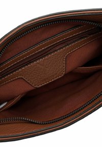 Interno di una borsa in pelle marrone con rivestimento in tessuto, numerosi scomparti con zip e aperti, e dettaglio con logo in rilievo su un pannello in pelle.