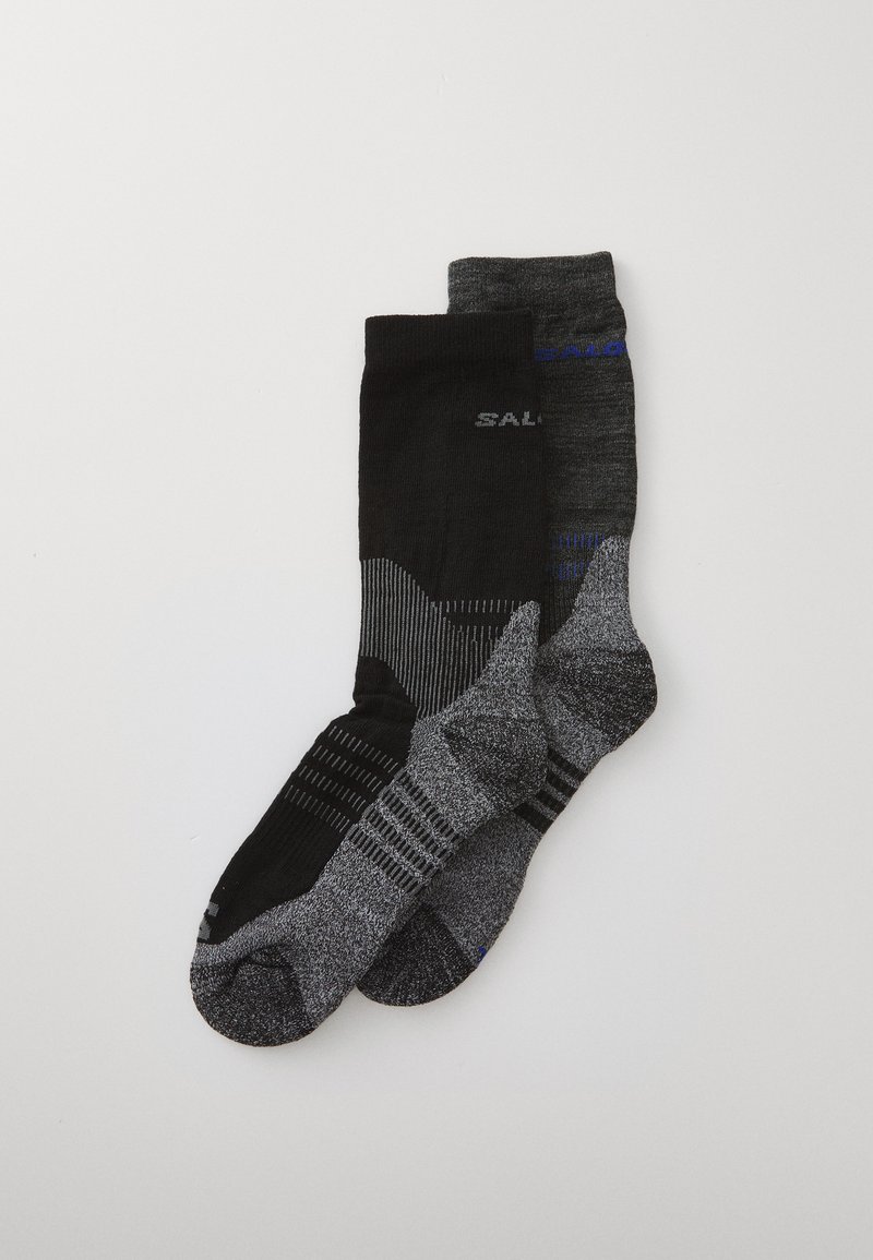 Schwarze und graue Socken mit unterschiedlichen Texturen; die schwarze Socke hat vertikale Streifen und ein Logo, während die graue Socke ein gesprenkeltes Design und horizontale Linien aufweist.