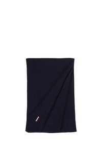Écharpe côtelée de couleur bleu marine foncé, pliée, avec une petite étiquette rouge, blanche et bleue près d'une extrémité.