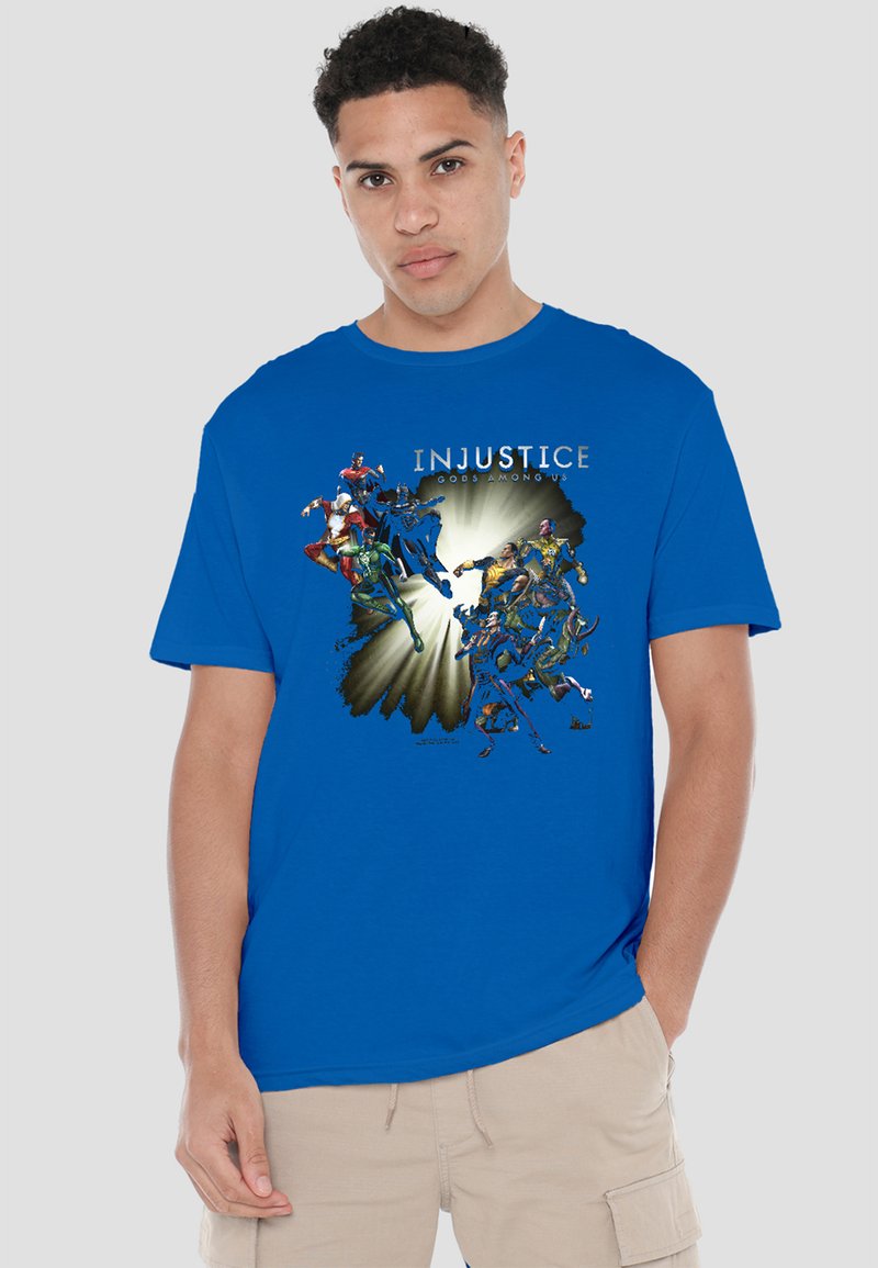 Young man wearing a blue T-shirt with Injustice: Gods Among Us logo and multiple comic-style superhero characters in dynamic poses.