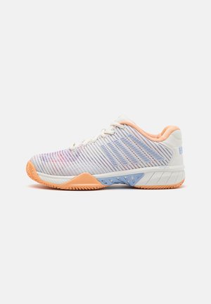 Chaussure de tennis avec une tige en maille blanche et dégradé pastel, des accents orange et bleu, et une semelle en caoutchouc texturé pour l'adhérence. Vue de côté affichée.