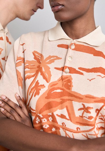 Gebreide polo in beige met een oranje strandtafereel, voorzien van een klassieke kraag en een drieknops sluiting, met een zachte textuur.