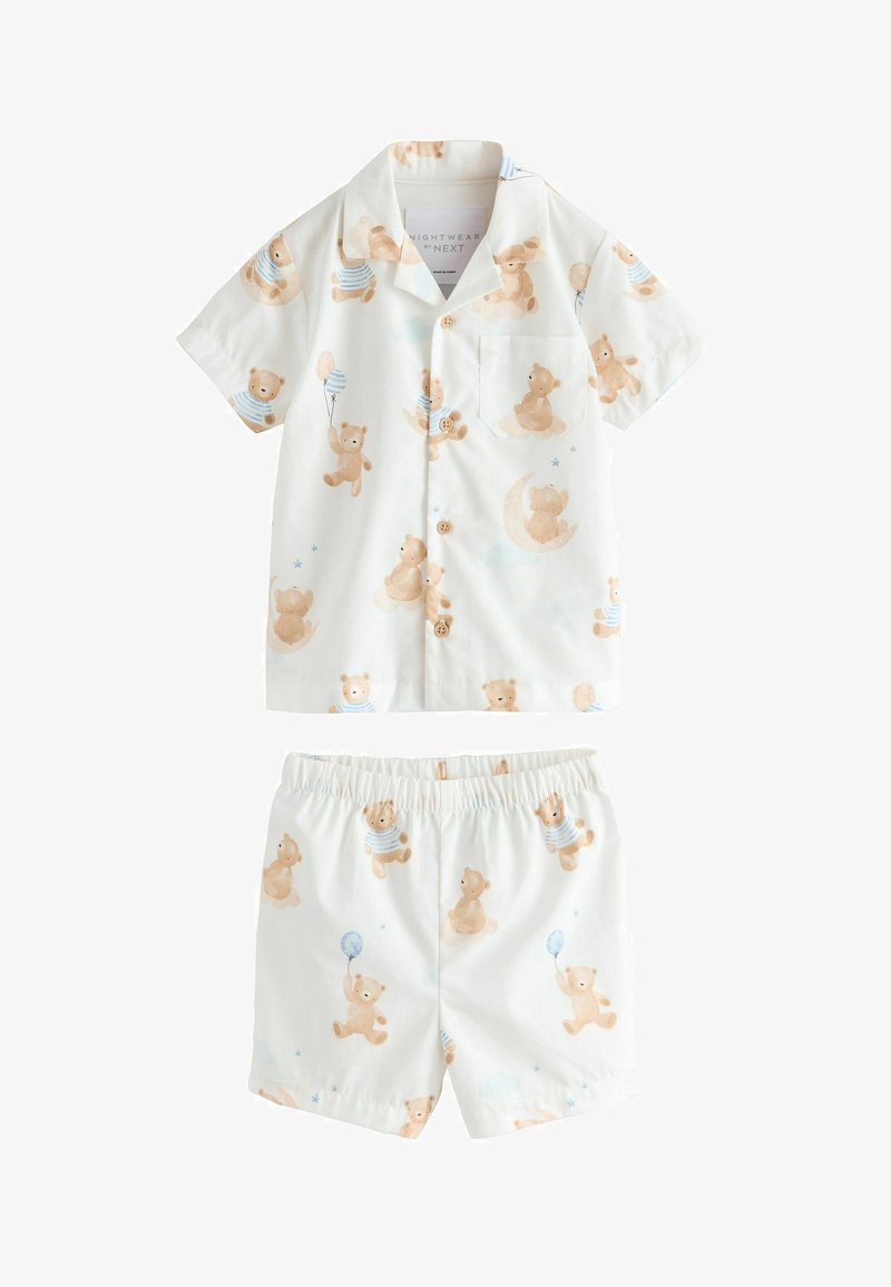 Ensemble composé d'une chemise blanche à manches courtes avec boutons et d'un short, illustré d'ours en peluche beige tenant des ballons et assis sur des lunes, dans des couleurs pastel douces.