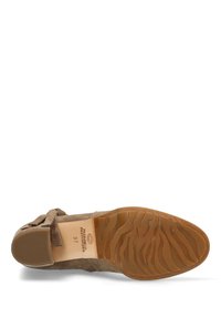 Chaussure en suede marron avec un talon plat, présentant un accent de nœud décoratif et une semelle en caoutchouc texturée avec des motifs en vagues. Taille 37 indiquée à l'intérieur.