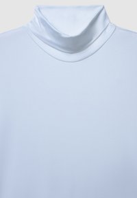 Biała bluzka z golfem o gładkiej, miękkiej fakturze i wyraźnym kołnierzu. Materiał wygląda na lekki i wysokiej jakości.