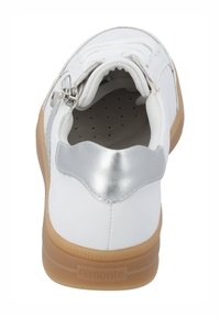 Sneaker blanche avec un cuir lisse, accent argenté au niveau du talon et semelle en caoutchouc naturel. Présente un système de laçage et un détail de zip.