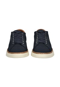 Granatowe sneakersy na sznurówki z teksturowanej tkaniny, beżowa gumowa podeszwa i brązowy akcent wokół podeszwy. Posiadają srebrne oczka i przeszycia.