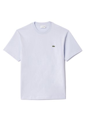 Světle modré bavlněné tričko, kulatý výstřih, krátké rukávy, s malým zeleným vyšitým logem na hrudi. Hladká textura.