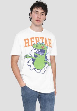 White cotton t-shirt featuring a green cartoon dinosaur breaking through, with "REPTAR" in orange above and a textured graphic design.