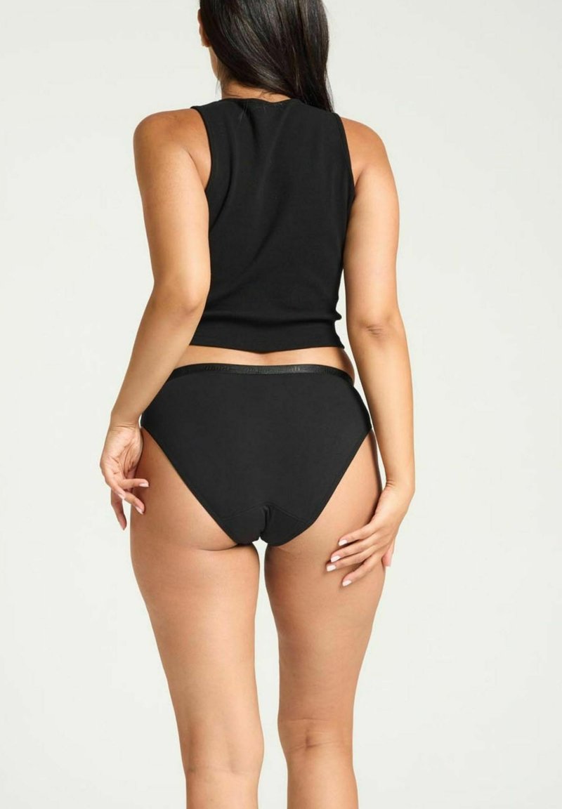 Haut sans manches noir et culotte taille haute assortie. Le tissu semble lisse avec un design ajusté et des coutures minimales, accentuant l'apparence épurée.