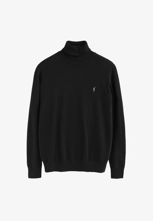 Pull en col roulé noir en tissu doux, avec des manches longues, des bords côtelés, et un petit accent brodé sur la poitrine.