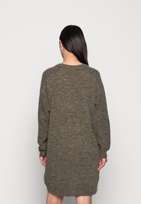 Abito maglione over size verde oliva con scollatura rotonda e maniche lunghe, caratterizzato da una texture morbida e una vestibilità comoda.