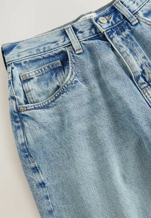 Jasnoniebieskie dżinsy z klasycznym pięciopocketowym wzorem, z wyblakłym wyglądem i widocznymi detalami przeszyć. Materiał ma miękką teksturę.