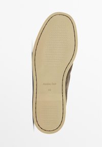 Semelle en caoutchouc beige avec un motif de grip texturé. Présente une bordure cousue et un logo en relief. Taille indiquée comme 42.