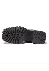 Suela de zapato de goma negra con un patrón de relieve profundo, que presenta secciones elevadas y acentos en forma de estrella para mejorar la tracción y la durabilidad.