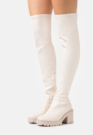 White thigh-high boots with a smooth faux leather texture, featuring a side zipper and a chunky platform heel.