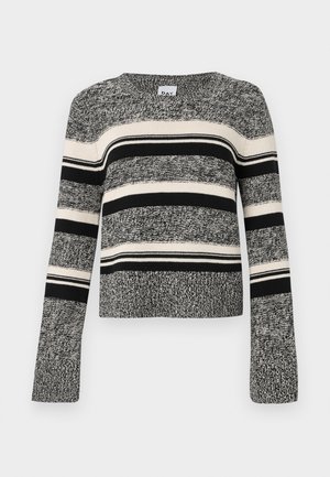 Suéter de rayas blancas y negras con cuello redondo. Material de punto texturizado. Mangas largas con puños acampanados. Rayas horizontales de diferentes anchos.