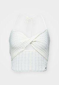 Top corto blanco con un diseño retorcido, que presenta una tela texturizada, tirantes delgados ajustables y patrones de costura sutiles.