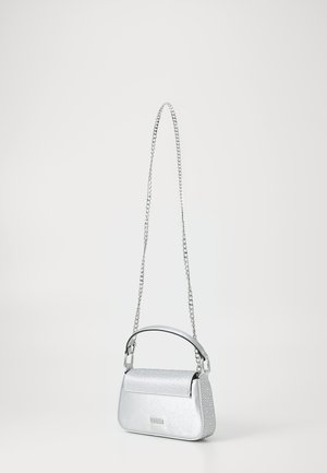 Petit sac à main argenté avec rabat clouté, poignée courte sur le dessus et longue bandoulière chaîne sur fond uni clair.