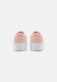 Pink suede sneakers with a white rubber sole and visible logo. Features a rounded toe and a soft, textured upper for comfort.