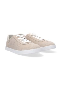 Beige Wildlederschuhe mit weißen Schnürsenkeln, perforiertem Design an den Seiten und strukturierten weißen Gummisohlen. Runde Zehenform und weicher Stofftextur.