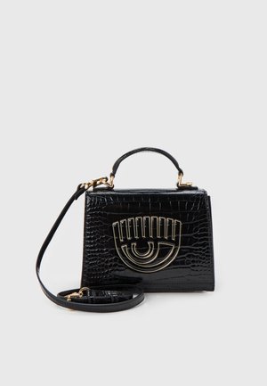 Zwarte croco-geembosserde handtas met een bovenhandvat, afneembare schouderriem en gouden oogvormige metalen details op de voorflap.