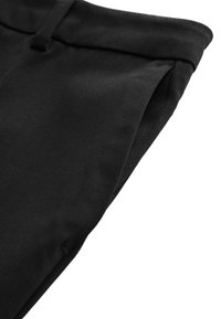 Zwarte katoen broeken met een gladde textuur. De tailleband heeft een kleine lus. De stof heeft een subtiele stretch voor comfort en pasvorm.