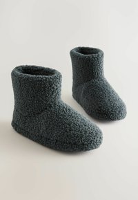 Ciemnoszare, pluszowe kapcie-buty wykonane z teksturowanej tkaniny, z wysokim fasonem na kostce i okrągłym palcem dla ciepła i komfortu.
