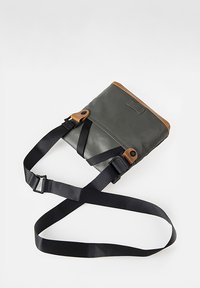 Rectangular grey bag made of durable material, featuring brown leather accents, adjustable black straps, and a flap closure.