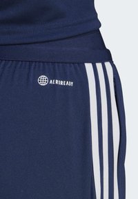 Shorts sportivi blu navy con accenti a strisce bianche, una vita sicura e il logo "AEROREADY" per prestazioni traspiranti.