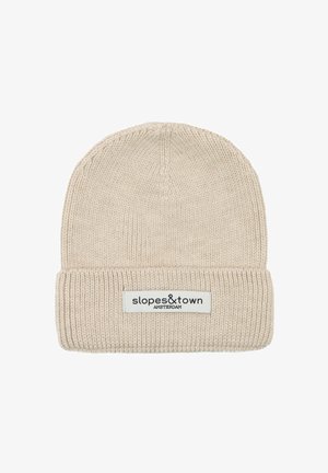 Cremfarbener gerippter Strickbeanie mit umgeschlagenem Bund, der ein weißes Etikett mit der Aufschrift "slopes&town AMSTERDAM" trägt.