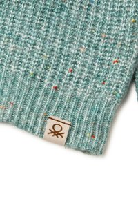 Dzianinowa czapka w odcieniu teal z kolorowymi plamkami. Posiada prążkowaną teksturę oraz naszywkę z prostym logo na dole.