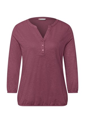 Dlouhý rukáv mauve košile s výstřihem do V, třemi knoflíky, elastickými manžetami a nařaseným elastickým lemem.