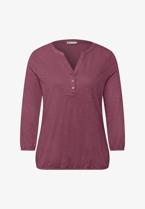 Dlouhý rukáv mauve košile s výstřihem do V, třemi knoflíky, elastickými manžetami a nařaseným elastickým lemem.