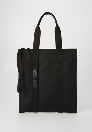 Sac fourre-tout noir en matériau durable avec des poignées courtes et une bandoulière réglable. Présente un logo en relief le long de la bandoulière.