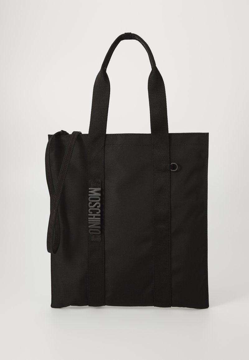 Black tote bag made of durable material with short handles and an adjustable shoulder strap. Features embossed logo along the strap.