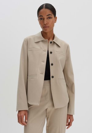 Beige Blazer aus glattem Stoff, mit klassischem Kragen, frontaler Knopfleiste und zwei Brusttaschen in strukturierter Passform.