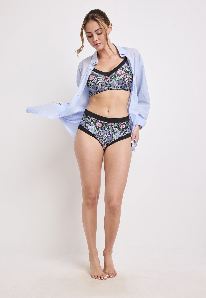 Bralette nera con motivo floreale e mutandine a vita alta con bordo in pizzo, abbinati a una camicia azzurro chiaro a bottoni. Tessuto morbido, vestibilità comoda.