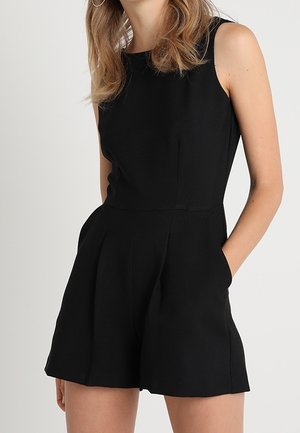 Czarny kombinezon bez rękawów z dopasowaną górą, szerokimi nogawkami i kieszeniami bocznymi. Gładki materiał o subtelnej fakturze i czystych liniach.