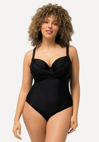 Maillot de bain noir une pièce avec soutien-gorge à armatures, tissu texturé, bretelles ajustables et design à l'avant croisé.