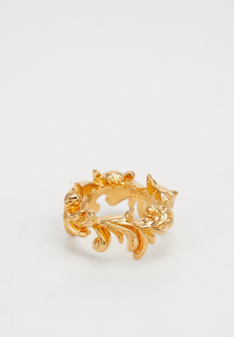 Anel de ouro com um intrincado design de folhas e vinhas. A banda é ornamentada com acentos enrolados e um acabamento polido.