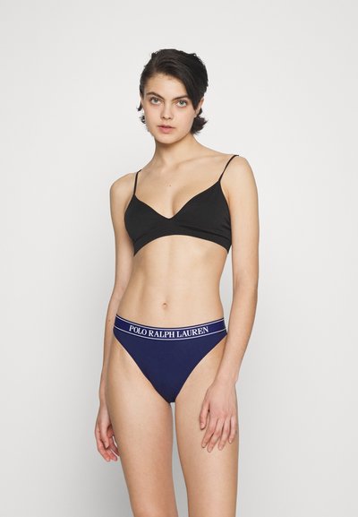 Mustmust ja õhukeste rihmadega V-kaelusega must bralette koos tumesiniste aluspükstega, millel on valge "POLO RALPH LAUREN" vöö.