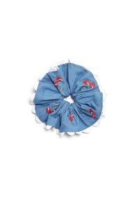 Fita de cabelo em denim com borda branca em formato de onda, apresentando desenhos florais bordados em vermelho e verde sobre um fundo azul.