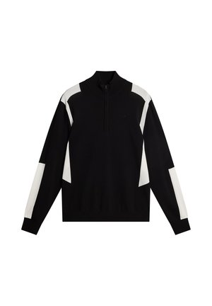 Zwart pullovertrui met een hoge kraag en een halve rits. Heeft witte geometrische panelen op de mouwen en de borst. Zacht gebreid materiaal.