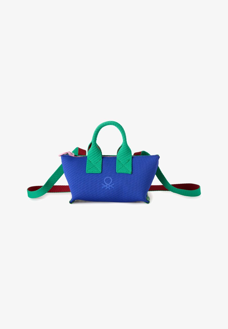 Kleine blaue Stoffhandtasche mit grünen Griffen, einem rot-grünen verstellbaren Schulterriemen und einem dezenten geprägten Logo auf der Vorderseite.