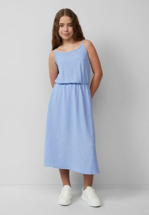 Himmelblaues, ärmelloses Kleid aus Strukturstoff, mit tailliertem Schnitt und Midi-Länge. Kombiniert mit weißen Sneakers für einen lässigen Look.