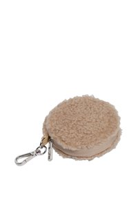 Runde beige Sherpa Tasche mit Reißverschluss und silbernem Schlüsselanhänger-Anhänger auf einem weißen Hintergrund.