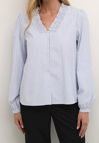 Blouse rayée bleue et blanche avec de longues manches bouffantes, décolleté en V froncé et fermeture à boutons sur le devant. Fabriquée en tissu léger.